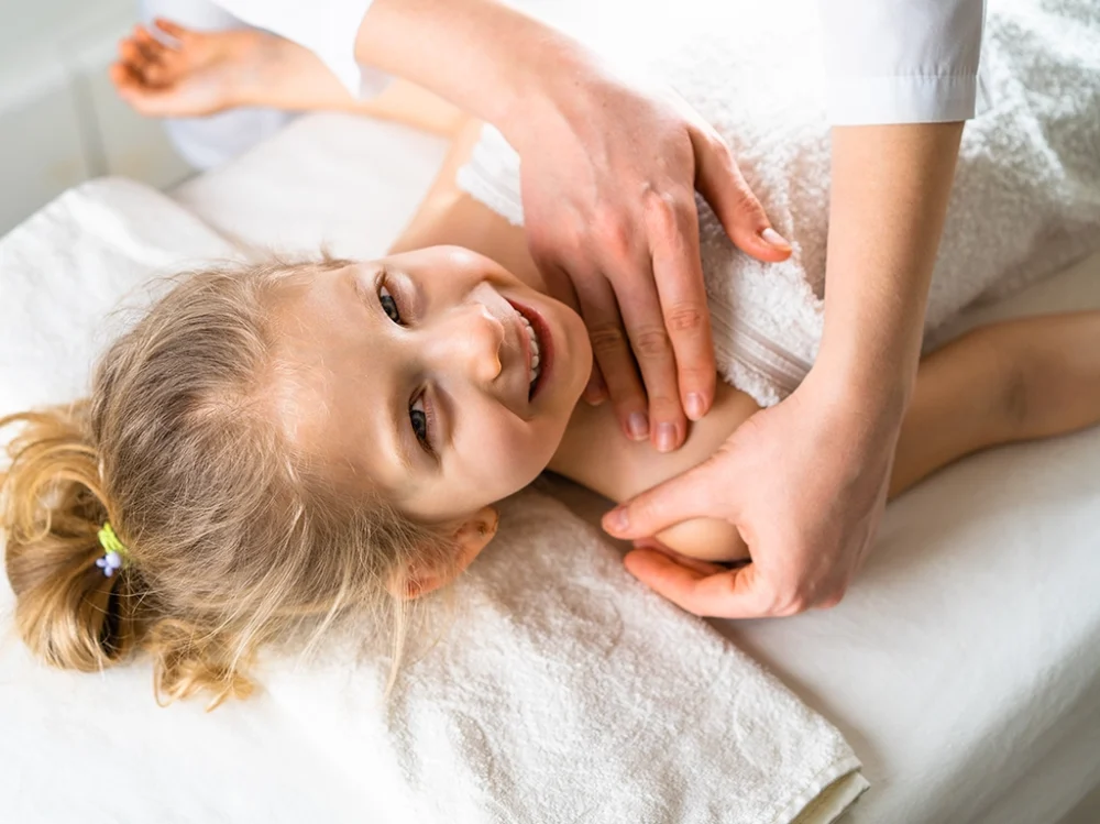 A kid getting a children's massage to support growth
